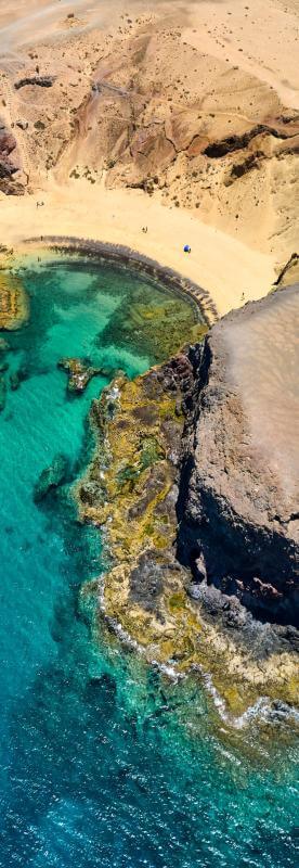 A Lanzarote szigetén található Papagayo strand, aranyszínű homokkal, vulkáni sziklákkal és türkiz tengerrel.